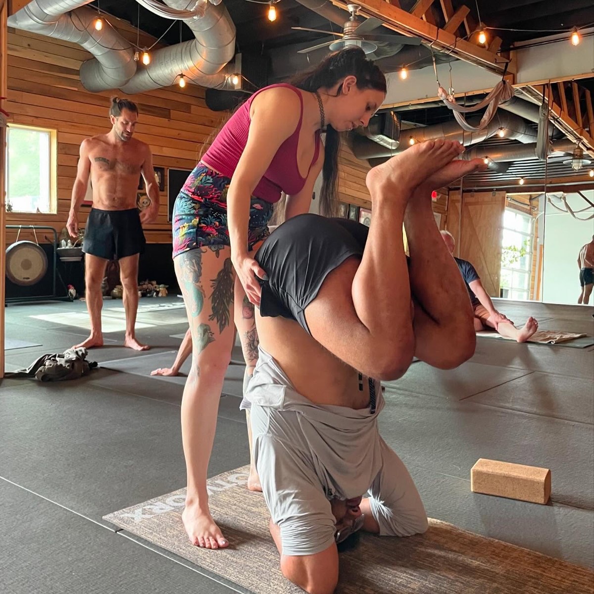 Philip Clift giving a hands-on adjustment in a seated forward fold