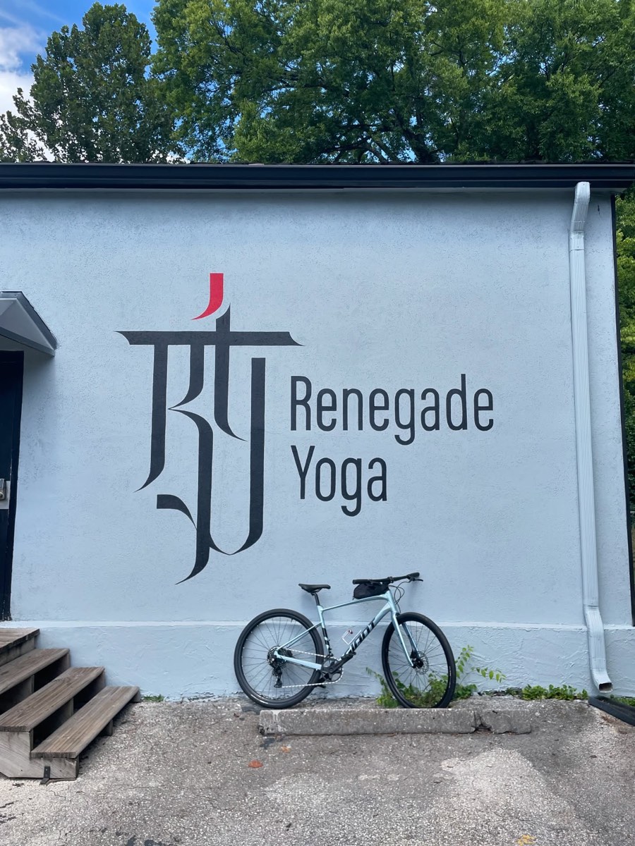 The white Renegade Yoga building at 516 Renford Rd, Knoxville, with the logo on the wall and a bike out front
