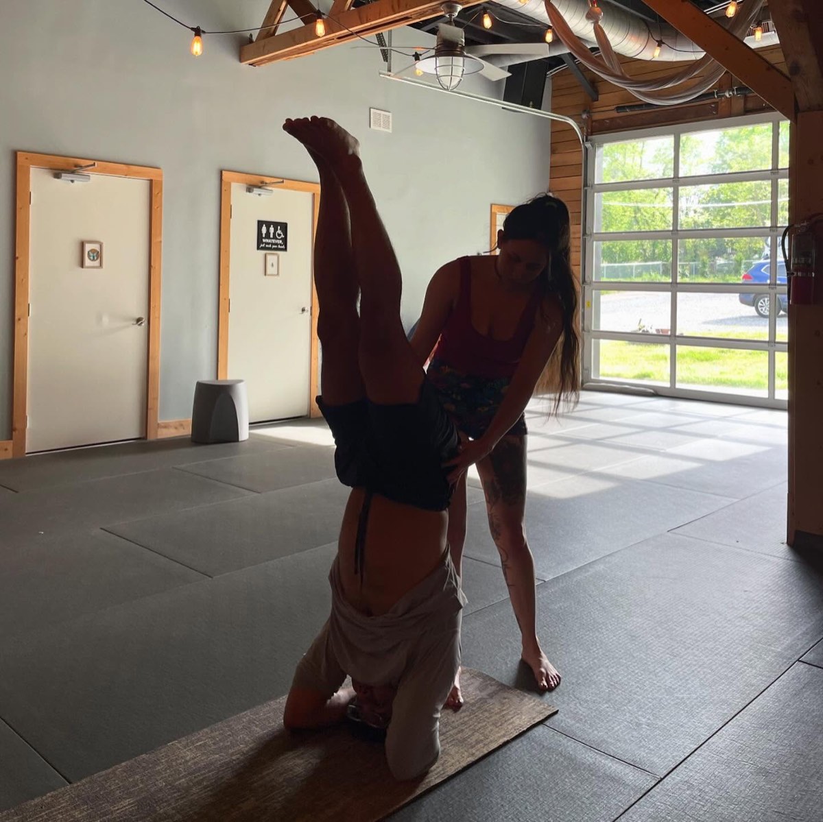 A student inverted beneath the aerial hammocks at Renegade Yoga